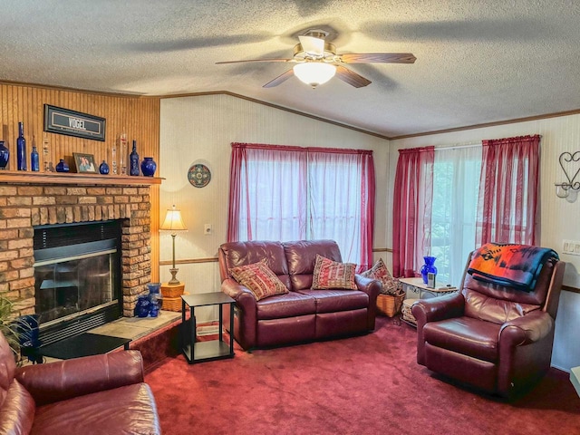 carpeted living area featuring ceiling fan, vaulted ceiling, crown molding, a textured ceiling, and a brick fireplace