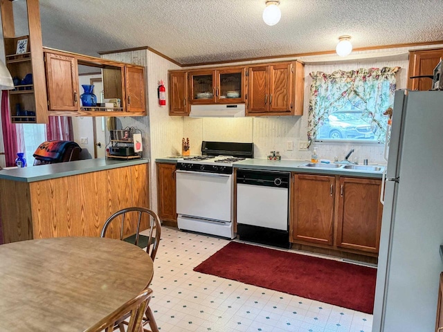 kitchen with brown cabinets, light floors, a sink, white appliances, and under cabinet range hood