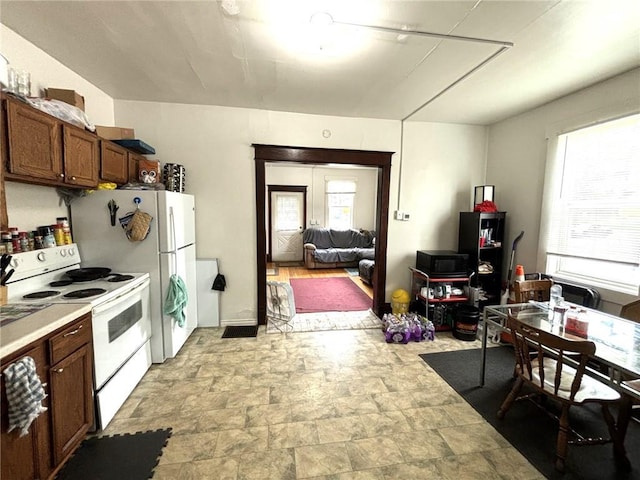 kitchen with a healthy amount of sunlight, white range with electric cooktop, and light tile patterned floors