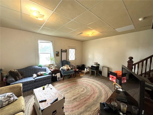 carpeted living room with a paneled ceiling