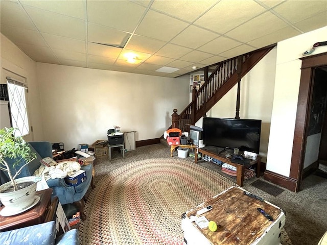 interior space featuring a paneled ceiling and carpet floors