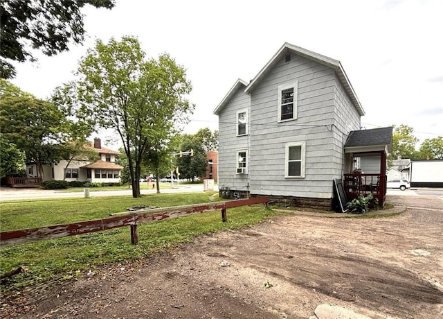 rear view of property featuring a lawn