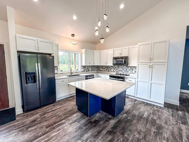 kitchen with a kitchen island, stainless steel appliances, sink, and dark wood-type flooring