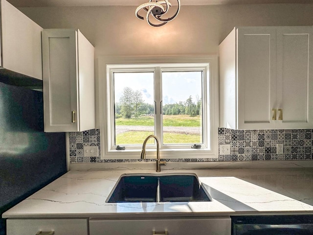 kitchen with white cabinets, a wealth of natural light, tasteful backsplash, and sink