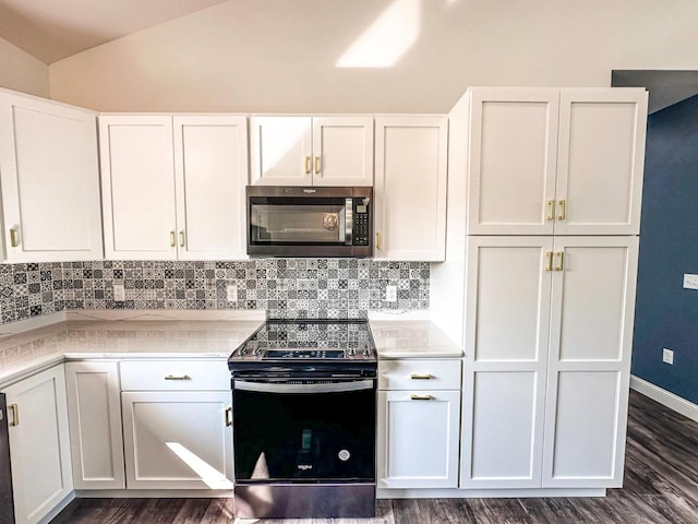 kitchen with white cabinets, appliances with stainless steel finishes, and dark hardwood / wood-style floors