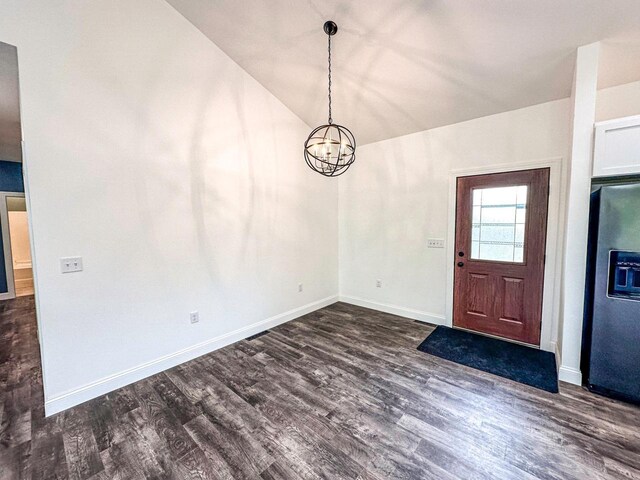 entryway with lofted ceiling, dark hardwood / wood-style floors, and an inviting chandelier