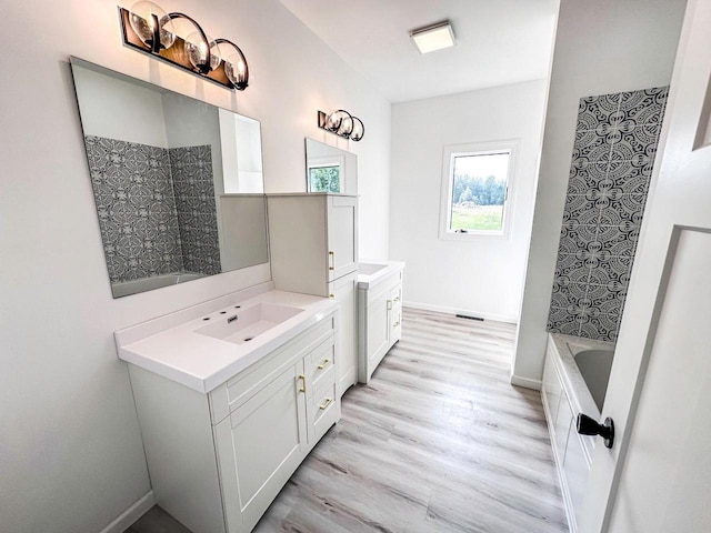 bathroom with vanity, independent shower and bath, and wood-type flooring