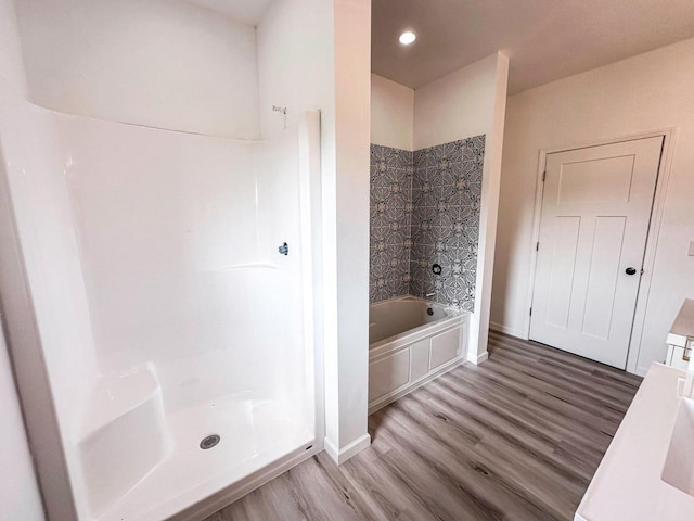 bathroom with vanity, tiled shower / bath combo, and hardwood / wood-style flooring