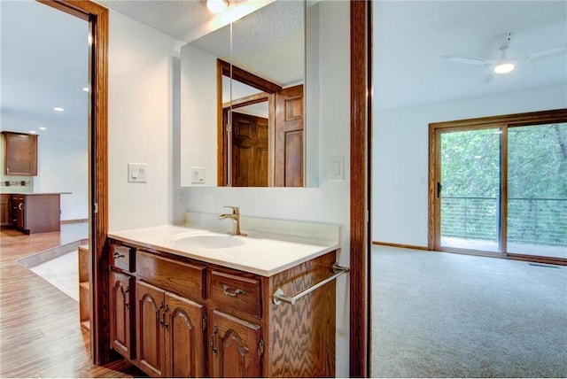 bathroom featuring hardwood / wood-style floors, ceiling fan, a textured ceiling, and vanity