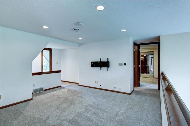 carpeted empty room featuring a textured ceiling