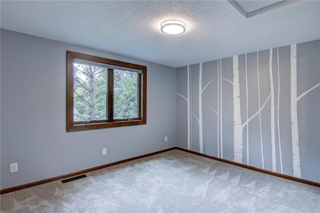 spare room featuring a textured ceiling and carpet floors