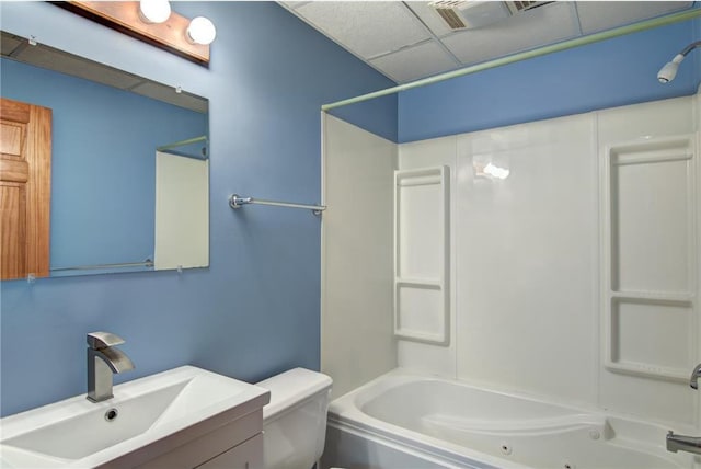 full bathroom featuring vanity, toilet, washtub / shower combination, and a drop ceiling