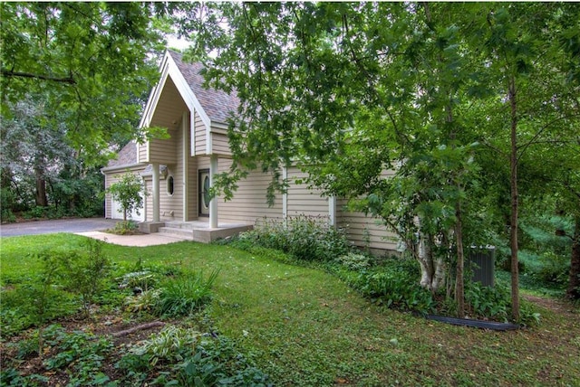 view of side of home featuring a garage and a lawn