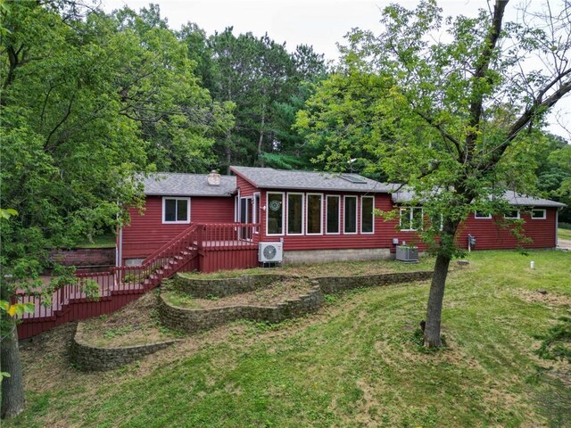 rear view of house with ac unit, a yard, and central AC unit