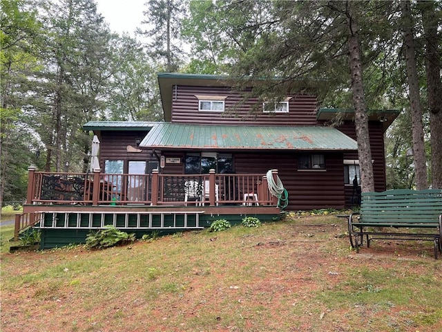 rear view of house with a wooden deck and a lawn