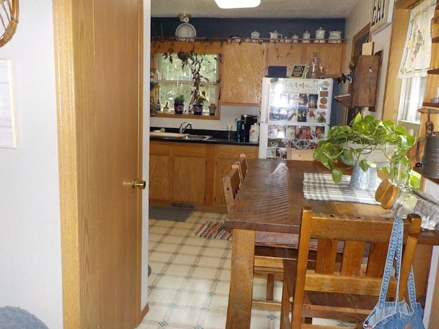 7112 Zielsdorf Dr, Webster, WI 54893 - kitchen featuring light floors, brown cabinetry, dark countertops, and a sink
