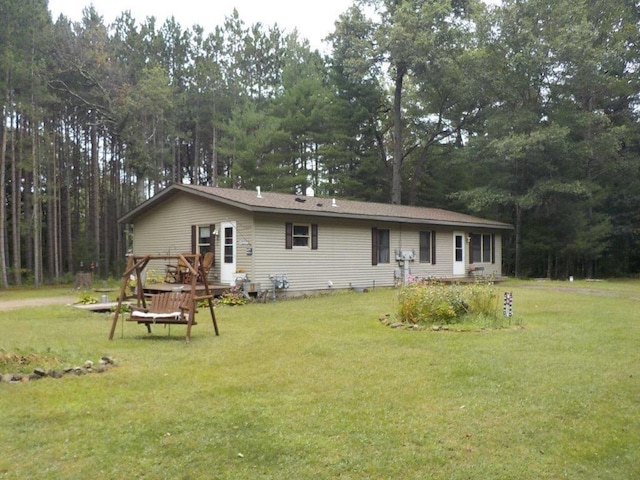 back of property featuring a yard and a wooden deck