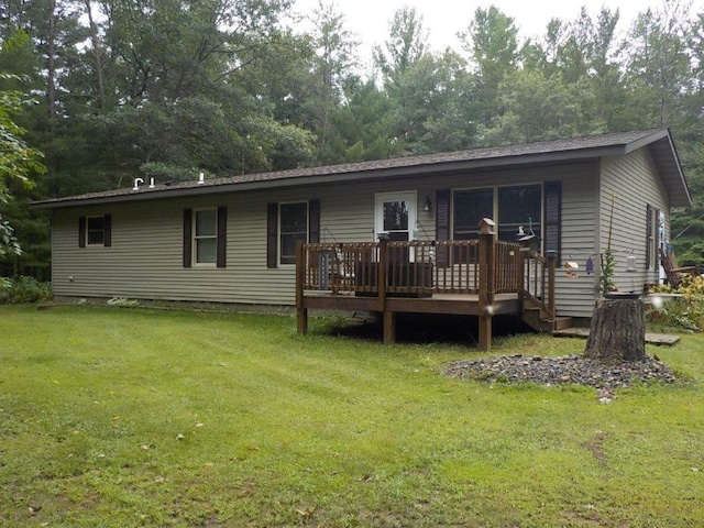 view of front of property featuring a front lawn and a wooden deck