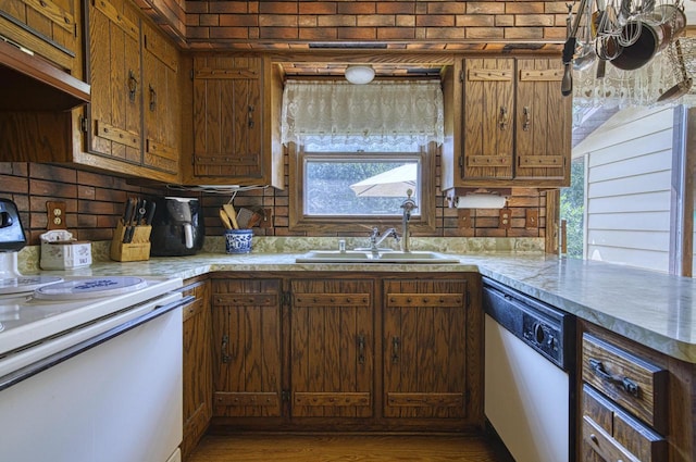 kitchen featuring stainless steel dishwasher, sink, electric range, and decorative backsplash