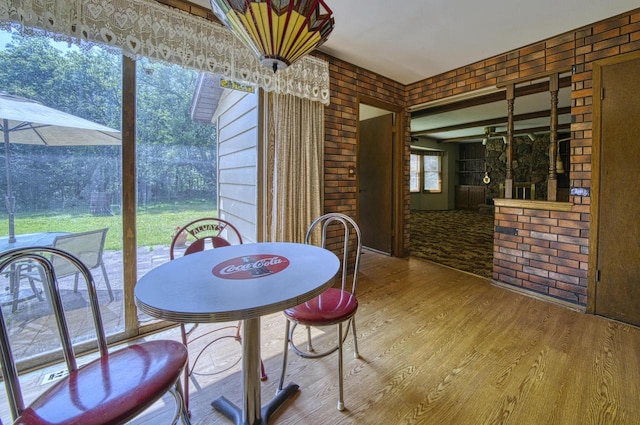 interior space with hardwood / wood-style flooring and brick wall