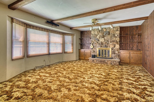 unfurnished living room with carpet flooring, wooden walls, and beam ceiling