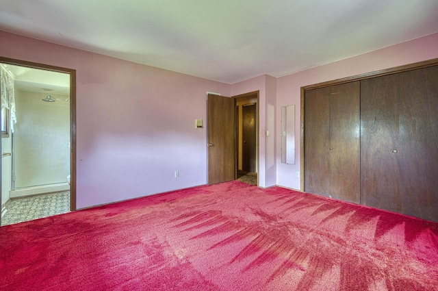 unfurnished bedroom with carpet, a closet, and ensuite bath