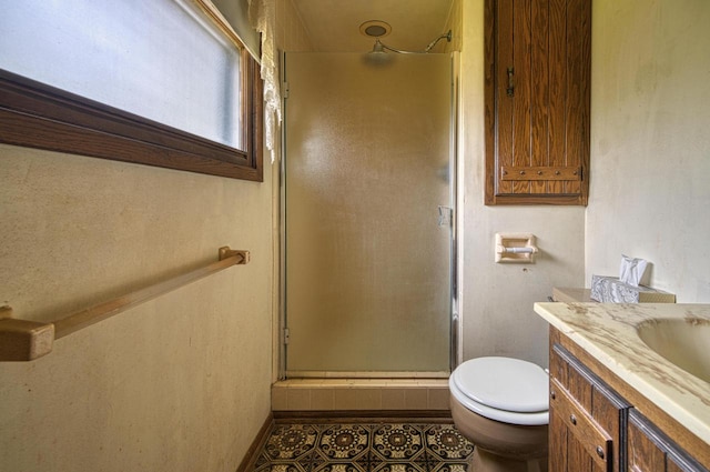 bathroom featuring tile patterned flooring, vanity, a shower with door, and toilet