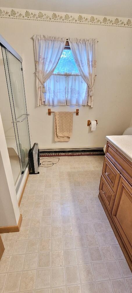 bathroom featuring tile patterned flooring, vanity, and walk in shower