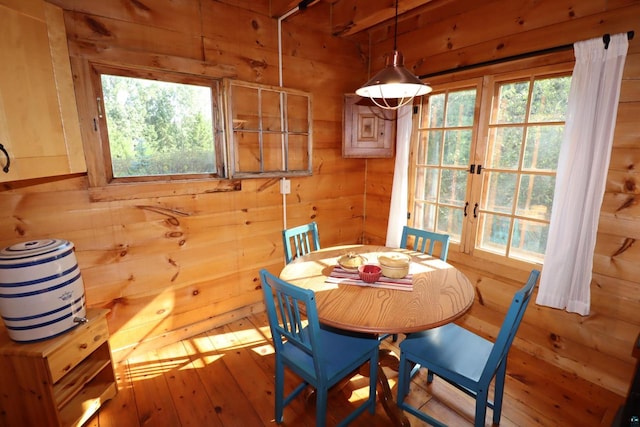 dining area with hardwood / wood-style flooring and wooden walls