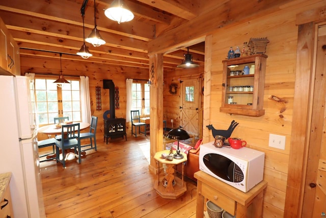 interior space featuring wooden walls, beamed ceiling, and light hardwood / wood-style flooring