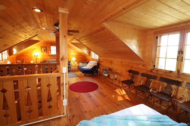 bedroom with wooden ceiling, lofted ceiling, hardwood / wood-style floors, and wood walls