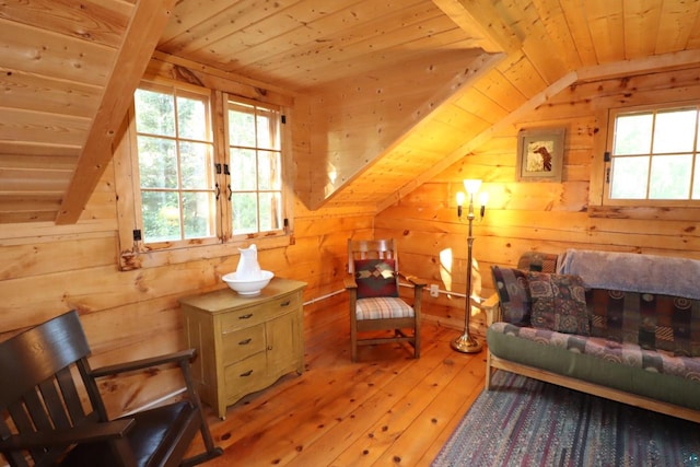 sitting room featuring lofted ceiling, light hardwood / wood-style flooring, wood walls, and wood ceiling