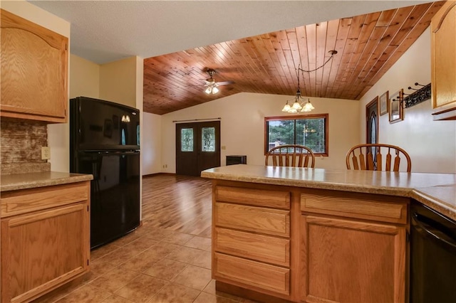 kitchen with vaulted ceiling, ceiling fan with notable chandelier, black appliances, pendant lighting, and wood ceiling