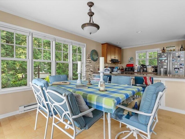 dining space featuring crown molding, a baseboard radiator, sink, and light hardwood / wood-style floors