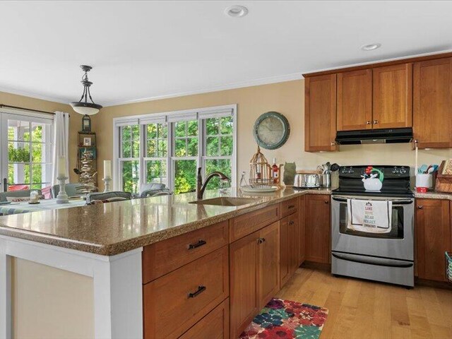 kitchen with stainless steel range with electric stovetop, pendant lighting, sink, light stone countertops, and light hardwood / wood-style floors