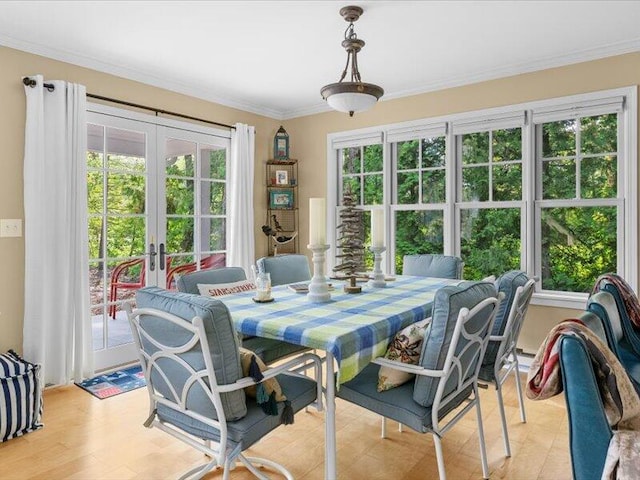 dining area featuring ornamental molding, french doors, plenty of natural light, and light hardwood / wood-style floors