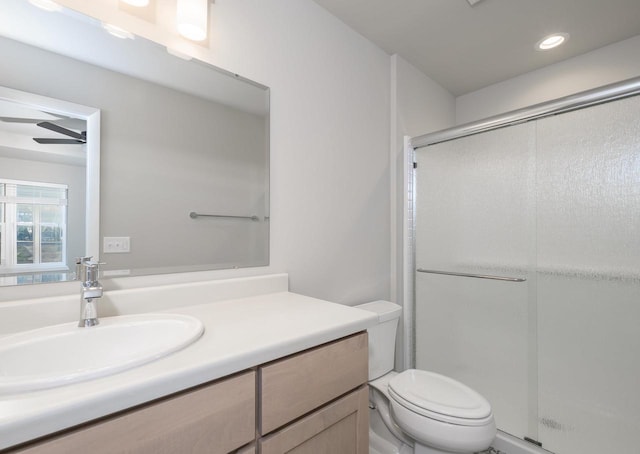 bathroom featuring vanity, an enclosed shower, and toilet