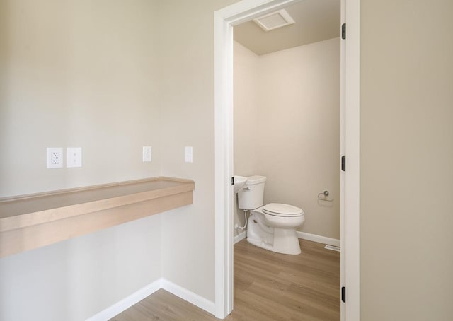 bathroom featuring wood-type flooring and toilet