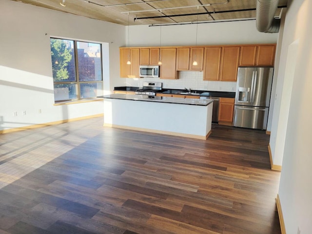 kitchen featuring track lighting, backsplash, dark hardwood / wood-style floors, pendant lighting, and stainless steel appliances