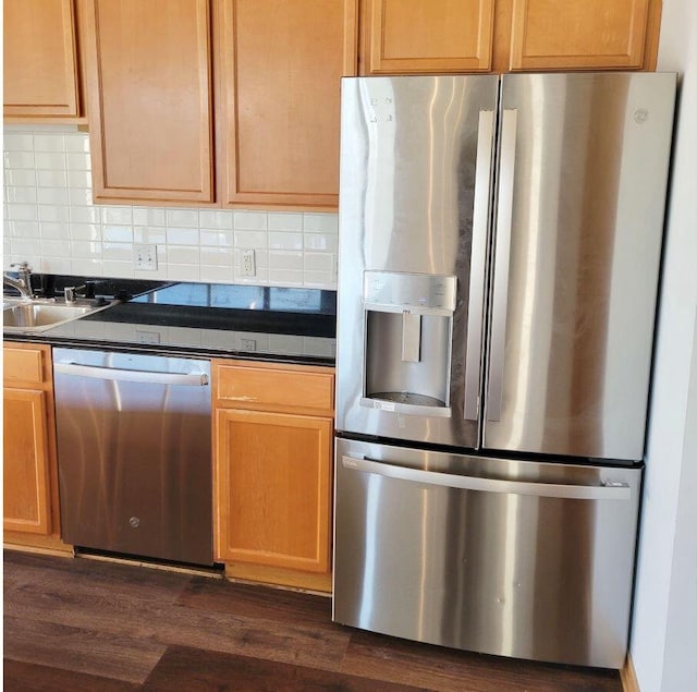 kitchen featuring sink, dark wood-type flooring, appliances with stainless steel finishes, and backsplash