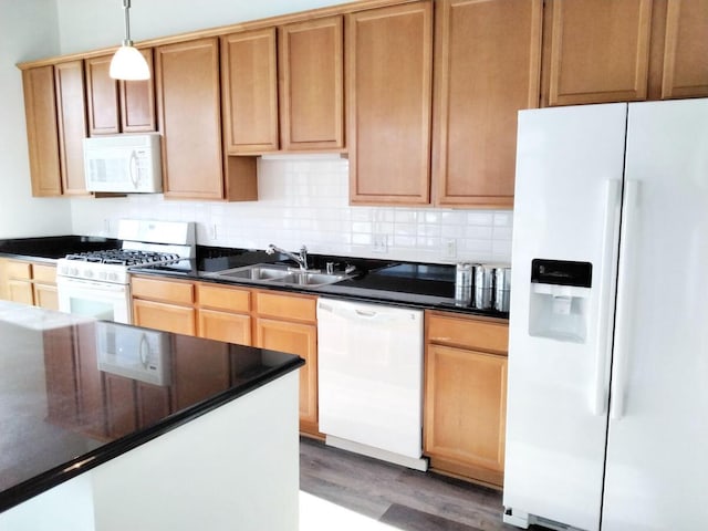 kitchen featuring decorative backsplash, hardwood / wood-style flooring, sink, pendant lighting, and white appliances