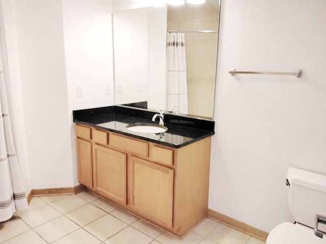 bathroom featuring toilet, walk in shower, vanity, and tile patterned floors