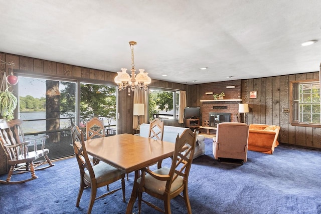 W11585 Demynck Rd, Lodi, WI 53555 - carpeted dining area featuring a healthy amount of sunlight, a brick fireplace, and wood walls