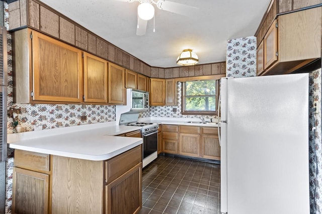 W11585 Demynck Rd, Lodi, WI 53555 - kitchen featuring light countertops, a sink, ceiling fan, white appliances, and a peninsula