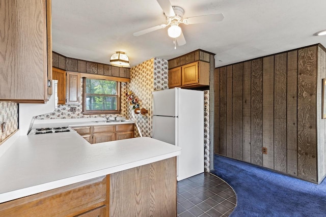 W11585 Demynck Rd, Lodi, WI 53555 - kitchen with wooden walls, freestanding refrigerator, a peninsula, light countertops, and a sink