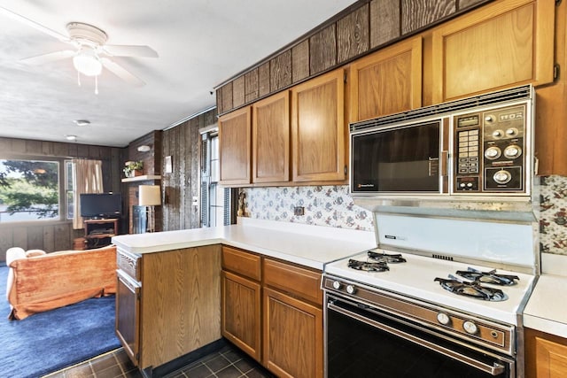 W11585 Demynck Rd, Lodi, WI 53555 - kitchen featuring white range with gas cooktop, brown cabinetry, a ceiling fan, a peninsula, and light countertops