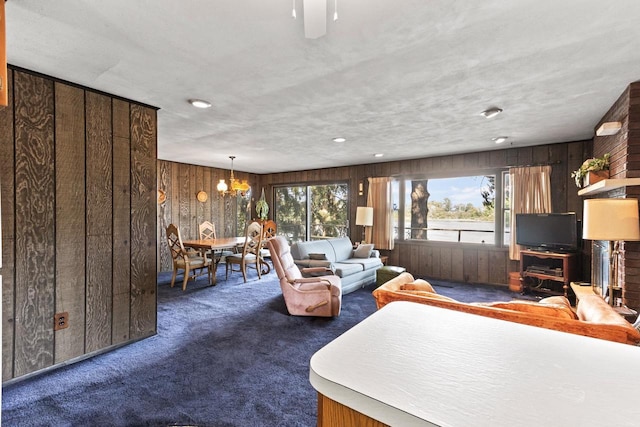 W11585 Demynck Rd, Lodi, WI 53555 - unfurnished living room featuring carpet floors, a chandelier, a healthy amount of sunlight, and wood walls