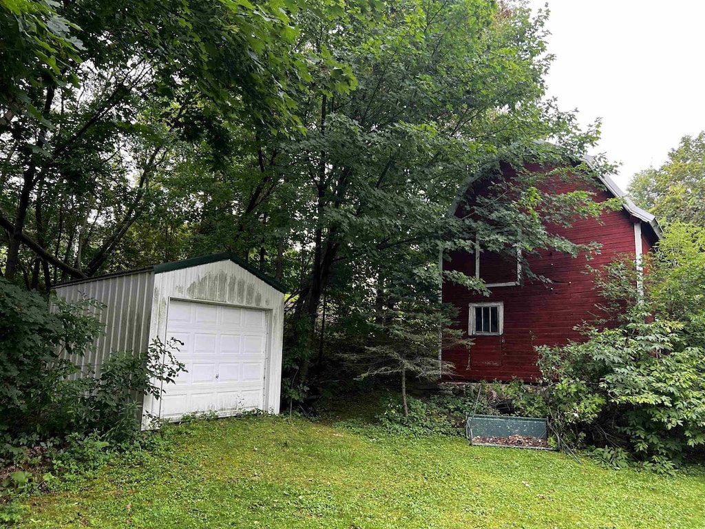 view of yard featuring a garage and an outbuilding