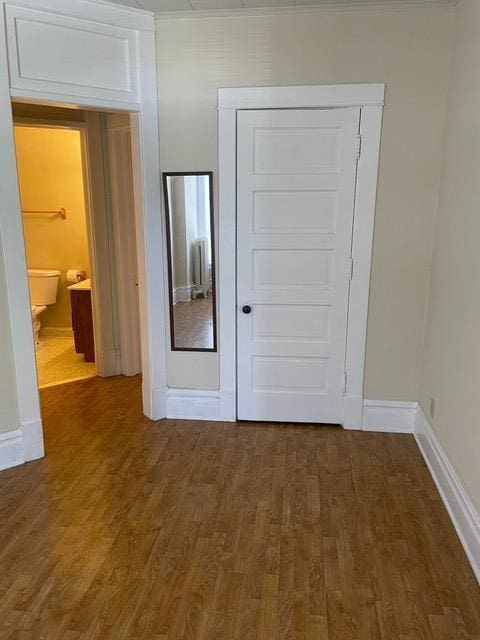 doorway featuring wood finished floors and baseboards