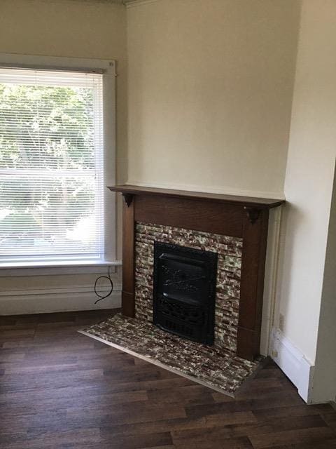 unfurnished living room featuring baseboards, wood finished floors, and a tile fireplace